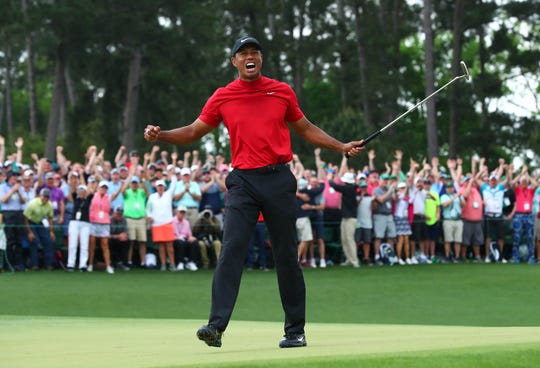Tiger Woods celebrates after putting a putt on the 18th green to win The Masters.