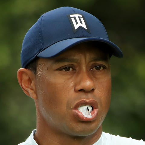 Tiger Woods blows a bubble during the second...