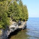 White, blocky cliffs that are part of the Niagara Escarpment line the Lake Michigan shoreline at Cave Point County Park in Door County.