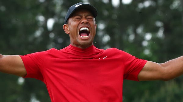 Tiger Woods celebrates after making a putt on the...