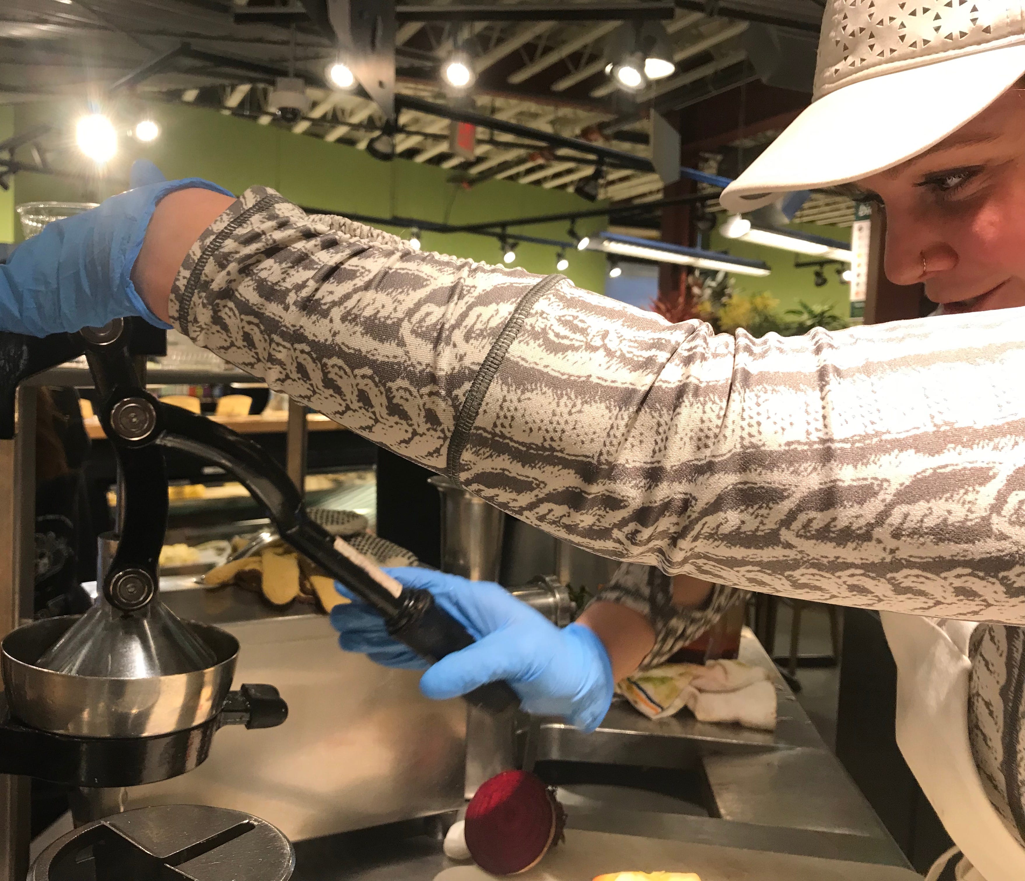 Melissa Cohen juices a lemon behind the barista counter at Healthy Living Market & Cafe. April 3, 2019.