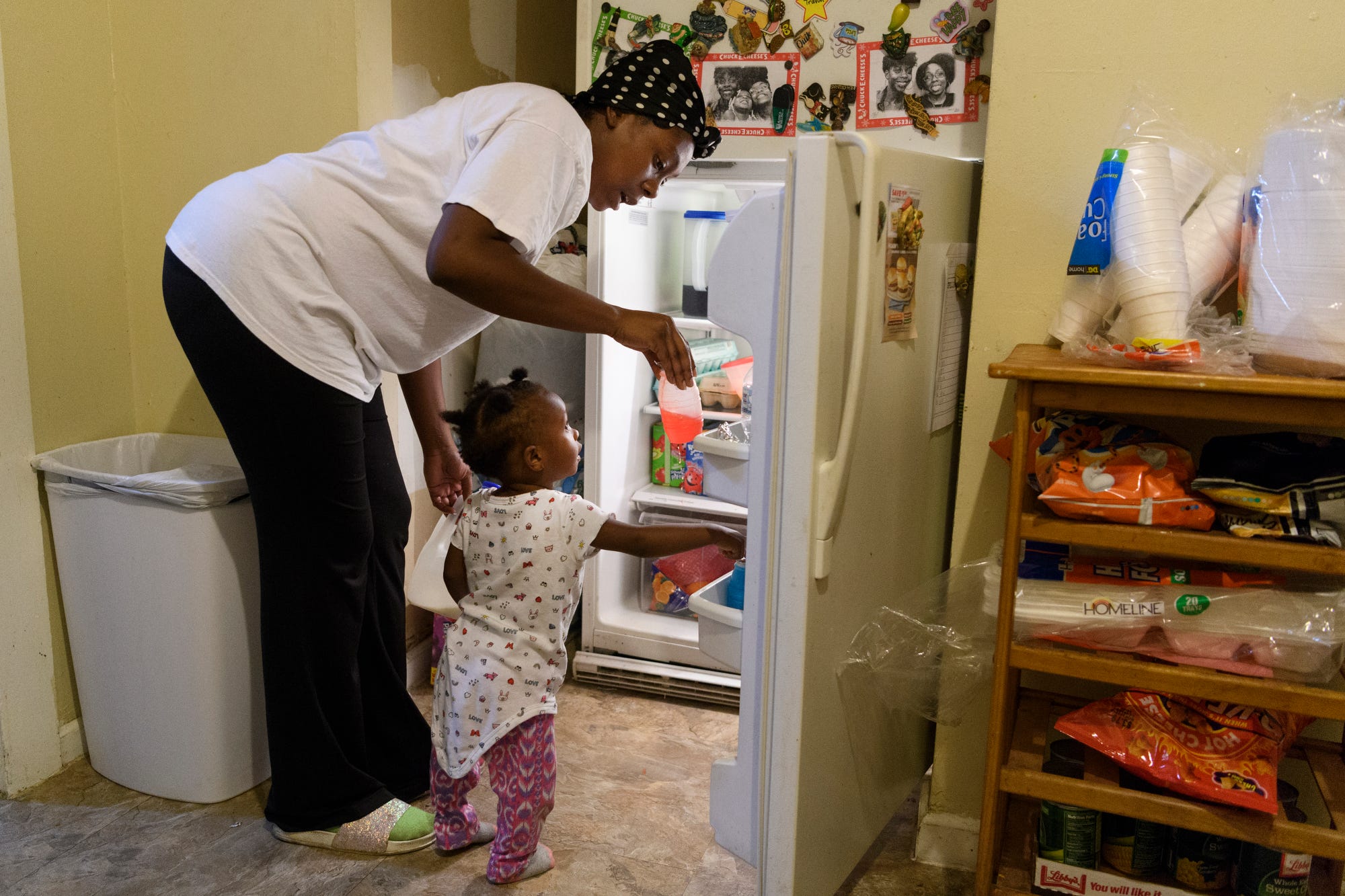 Tamisha Dilworth hands her youngest daughter Teresa, 1, a drink before serving her three children dinner at her father's house in Evansville, Ind., Monday, Sept. 24, 2018. Dilworth saved money by moving out of a three-bedroom apartment to live with her father, Robert Bradley, not pictured, for seven months while working through the nearly year-long  Habitat for Humanity program. 