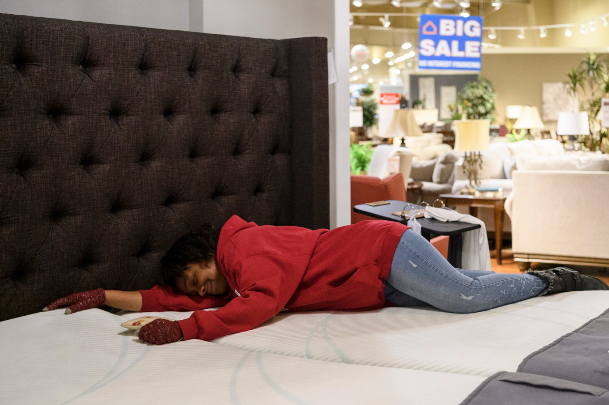 Tamisha Dilworth tests out the comfort of a mattress as she shops for furniture at Ashley HomeStore in Evansville, Friday afternoon, March 1, 2019.  Her new four-bedroom house provided a blank canvas of walls to decorate and an endless array of furniture options for herself and her children. 