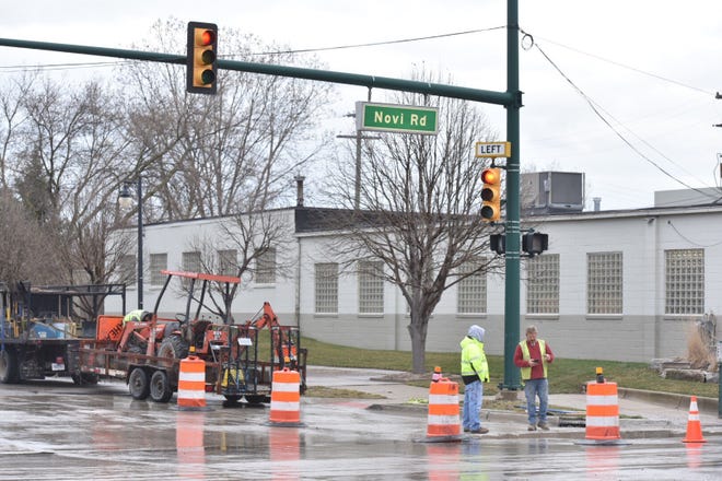 Orange barrels block off a lane of Novi Road near Main Street on April 16 as workers finish up closing a hole made in the pavement to re-direct a gas line under the surface.