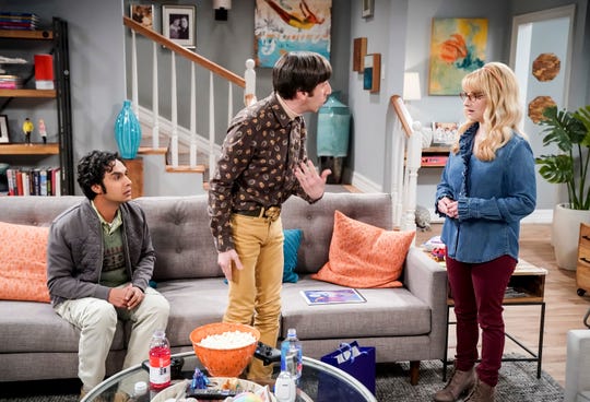 (Kunal Nayyar), on the left, listens as his friends, Howard's partners (Simon Helberg) and Brandt (Melissa Roach), discuss the episode of CBS The Big Bang theory.