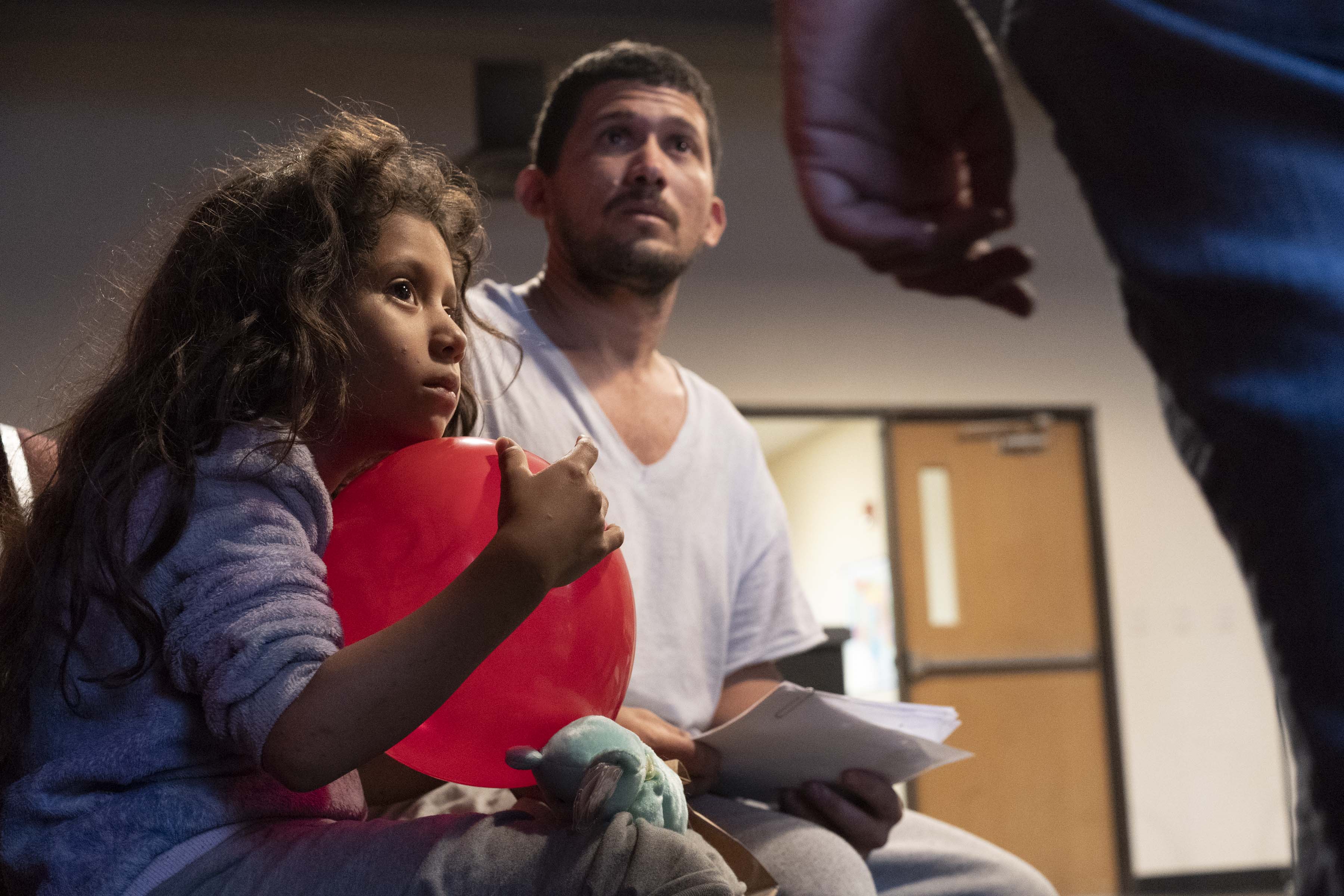Guatemalan father Marvin Cano, 28, with his daughter Maricela Cano, 7, consults with a medical worker about a skin irritation.