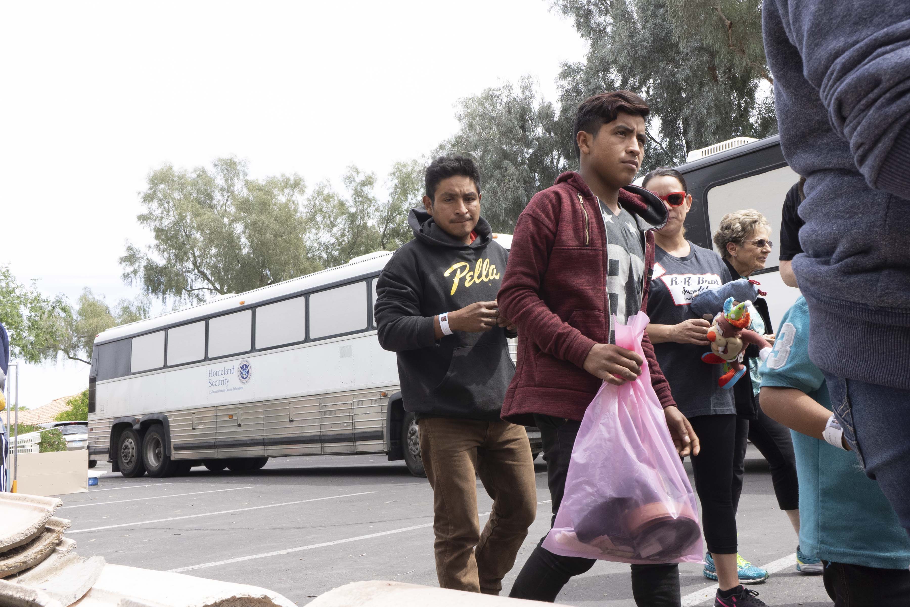 Guatemalan national Modesto Martin-Diaz, 33, (on left) with his son Edgar, 16, arrives in an ICE bus with other asylum seekers at at the church.