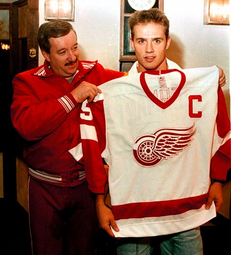 Red Wings coach Jacques Demers gives the Captain's jersey to Steve Yzerman at Oak Park Arena on Oct. 7, 1986.