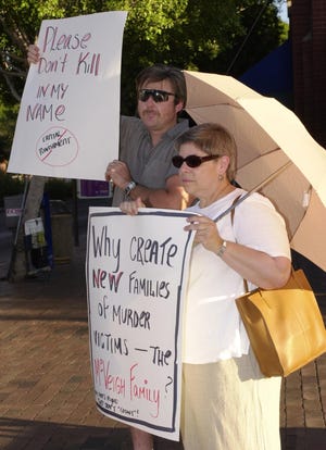 Jim Whitesell of Tempe and Eleanor Eisenberg hold signs in downtown Tempe in protest of the death penalty.  About a dozen protesters stood on the corner of 6th Ave. and Mill on the eve of Timothy McVeigh's execution.