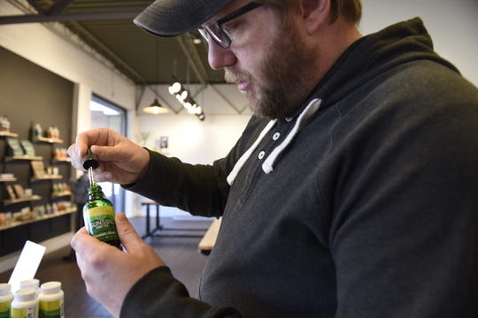 Joshua Sopko, co-founder of Juniper Apothecary, explains how to use a dropper of CBD oil. Juniper received its first shipment of SUNSoil CBD petroleum products about two weeks ago.