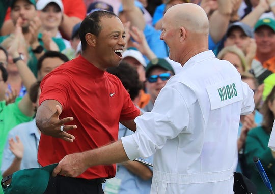 Tiger Woods celebrates with his junior Joe LaCava at the 18th green after winning the Masters.
