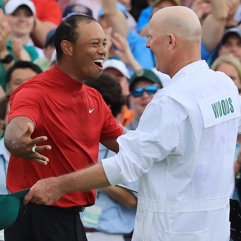 Tiger Woods celebrates with caddie Joe LaCava on...