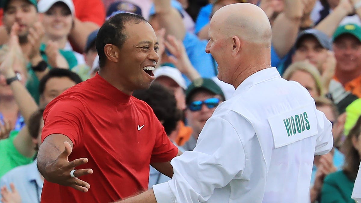 Tiger Woods celebrates with caddie Joe LaCava on the 18th green after winning the Masters.