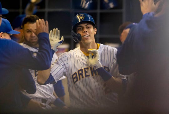 Christian Yelich celebrates his second game of the match with his teammates in the sixth inning.
