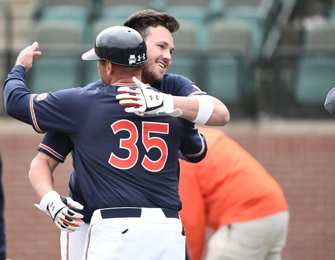 Auburn's Conor Davis hugs assistant Karl Nonemaker (35) after hitting a walk-off single to beat Ole Miss on April 20, 2019.