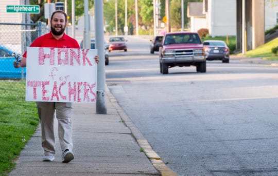 Tekoppel Elementary teacher Wesley Scherzinger holds a bike horn and as sign as he stand in front of his school while participating in Indiana's "Red for Ed" Teacher Walk-in Tuesday, April 23, 2019. Teachers across Indiana participated in the walk-in to send a message to state legislators.