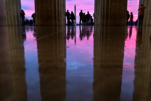 Spectators watch the first sunrise of the new year from the steps of the Lincoln Memorial in Washington early Tuesday, Jan. 1, 2019. (AP Photo/J. David Ake) ORG XMIT: DCDA101