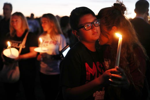 Carol Ortez hugs her son, Aaron Ortez, as he holds a candle during a memorial service at Pine Trails Park for the victims of the mass shooting at Marjory Stoneman Douglas High School on Feb. 14, 2019 in Parkland, Fla. A year ago on Feb. 14th at Marjory Stoneman Douglas High School 14 students and three staff members were killed during the mass shooting.