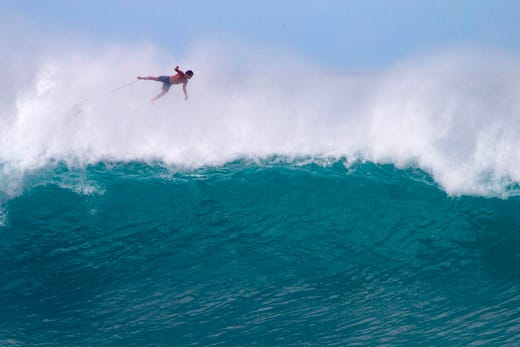 TOPSHOT - Hawaii's Billy Kemper falls off his board during the Da Hui Backdoor shootout at the Pipeline on Oahu's North Shore on January 13, 2019. (Photo by brian bielmann / AFP) / RESTRICTED TO EDITORIAL USEBRIAN BIELMANN/AFP/Getty Images ORIG FILE ID: AFP_1C77UC