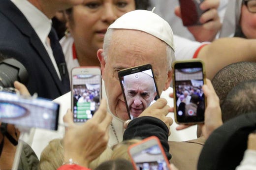Pope Francis is framed by cellphones as he arrives for his weekly general audience, in the Pope Paul VI hall, at the Vatican, Wednesday, Jan. 9, 2019. (AP Photo/Andrew Medichini) ORG XMIT: AJM101