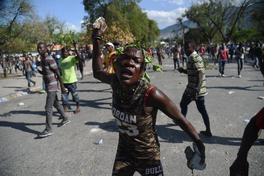 A demonstrator gestures during clashes in front of the National Palace, in the centre of Haitian Capital Port-au-Prince, Feb. 13, 2019, on the seventh day of protests against Haitian President Jovenel Moise and the misuse of the Petrocaribe fund.
