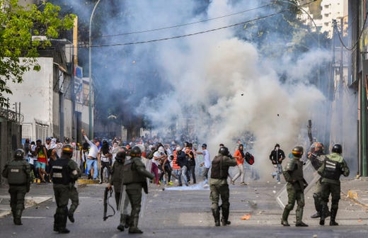 TOPSHOT - Riot police clash with opposition demonstrators during a protest against the government of President Nicolas Maduro on the anniversary of the 1958 uprising that overthrew the military dictatorship, in Caracas on January 23, 2019. - Venezuela's National Assembly head Juan Guaido declared himself the country's "acting president" on Wednesday during a mass opposition rally against leader Nicolas Maduro. (Photo by YURI CORTEZ / AFP)YURI CORTEZ/AFP/Getty Images ORIG FILE ID: AFP_1CK5EZ