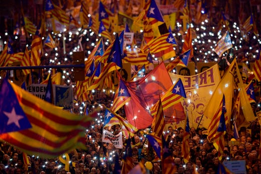Demonstrators hold portraits of jailed Catalan separatist Oriol Junqueras and wave Catalan pro-independence Estelada flags during a protest against the trial of former Catalan separatist leaders in Barcelona on Feb. 16, 2019. Twelve Catalan separatist politicians and activists face years behind bars if they are convicted of rebellion or other charges for pushing an independence referendum in October 2017, in defiance of a court ban, and a brief declaration of independence. 