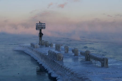 A harbor light is covered with snow and ice on the Lake Michigan at 39th Street Harbor, Wednesday, Jan. 30, 2019, in Chicago. A deadly arctic deep freeze enveloped the Midwest with record-breaking temperatures on Wednesday, triggering widespread closures of schools and businesses, and prompting the U.S. Postal Service to take the rare step of suspending mail delivery to a wide swath of the region. (AP Photo/Nam Y. Huh) ORG XMIT: ILNH116