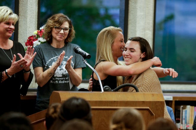 Maggie Huston, right, embraces Arielle Redmon as she receives the first Kristi Redmon Scholarship, Thursday, April 25, 2019 at Lafayette Jefferson High School in Lafayette. Kristi Redmon, Arielle's mother, an elementary school art teacher, was killed in her Lafayette home in Oct. 2016.