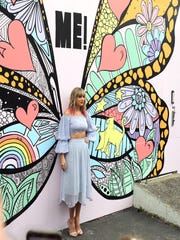 Taylor Swift poses in front of a butterfly mural in Nashville, Tennessee on Thursday, April 25, 2019.