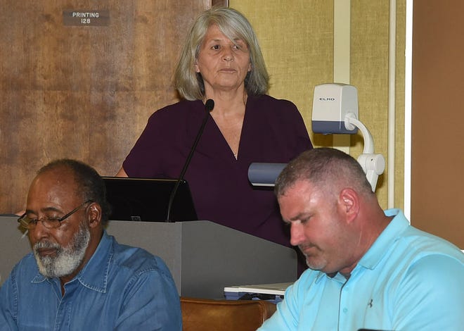Nichole Boudreaux (background) presents a proposal during a St. Landry Parish School Board public hearing for a proposed French immersion school in Sunset. Listening to Boudreaux are board members Anthony Stadnberry (left) and Josh Boudreaux. Fred Herpin photo.