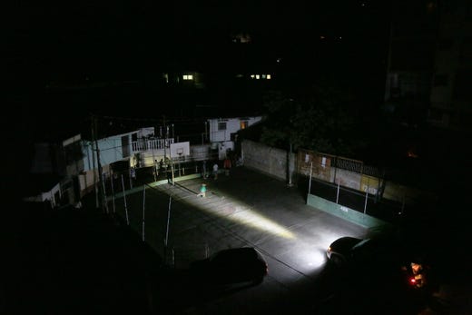 Residents use a car's headlamps as a source of light after a nationwide blackout occurred March 10, 2019 in Caracas, Venezula. Over seventy percent of the country was in darkness amid an ongoing political dispute between President Nicolas Maduro and self-declared interim president, Juan Guaido.