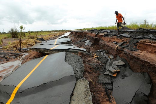 A man walks through a section of a road damaged by Cyclone Idai in Nhamatanda, Mozambique on March, 22, 2019. 