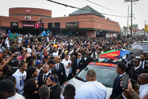 Hundreds of supporters cheer and watch as Nipsey Hussle's casket passes The Marathon Store on the corner of Crenshaw and Slauson in Los Angeles on April 11, 2019.