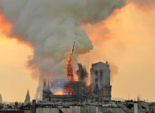Flames and smoke rise from the blaze as the spire starts to topple on Notre Dame cathedral in Paris, April 15, 2019. An inferno that raged through Notre Dame Cathedral for more than 12 hours destroyed its spire and its roof but spared its twin medieval bell towers, and a frantic rescue effort saved the monument's "most precious treasures," including the Crown of Thorns purportedly worn by Jesus, officials said.