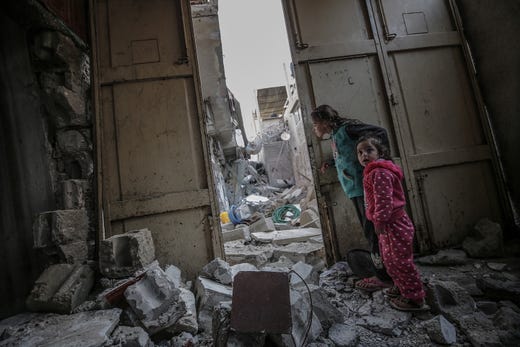 Palestinian sisters look at a destroyed Hamas site close their family's destroyed house after an Israeli air strike in Gaza City, March 26, 2019. According to reports, Israel continued to launch air strikes on the Gaza Strip overnight after a rocket allegedly fired from the Gaza Strip hit a house near Tel Aviv in central Israel injuring at least seven people. 