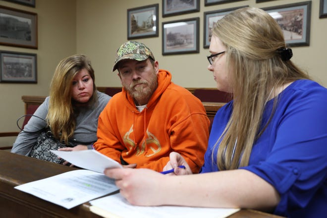 Eddie McElfresh and his fiancee Jenna Nichols talk with Southeastern Ohio Legal Services lawyer Ann Roche during the Don't Hesitate to Reinstate driver's license reinstatement clinic in New Lexington on Friday.
