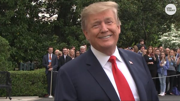President Trump smiles at reporters outside the...