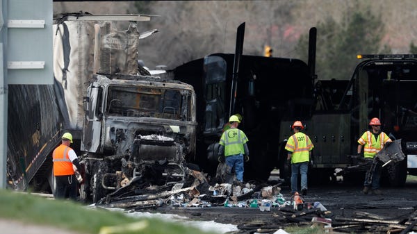 Workers clear debris from the eastbound lanes of...