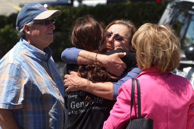 Members of the Chabad synagogue hug as they gather near the Altman Family Chabad Community Center, Saturday, April 27, 2019 in Poway, California.