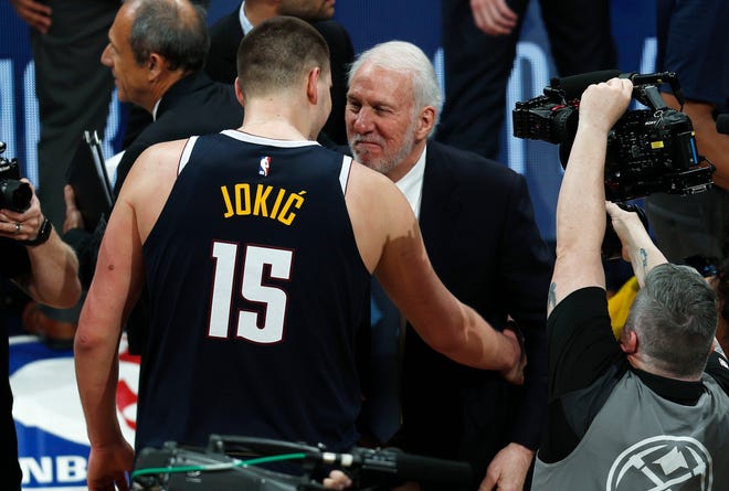 San Antonio Spurs head coach Gregg Popovich, right, congratulates Denver Nuggets center Nikola Jokic after Game 7.