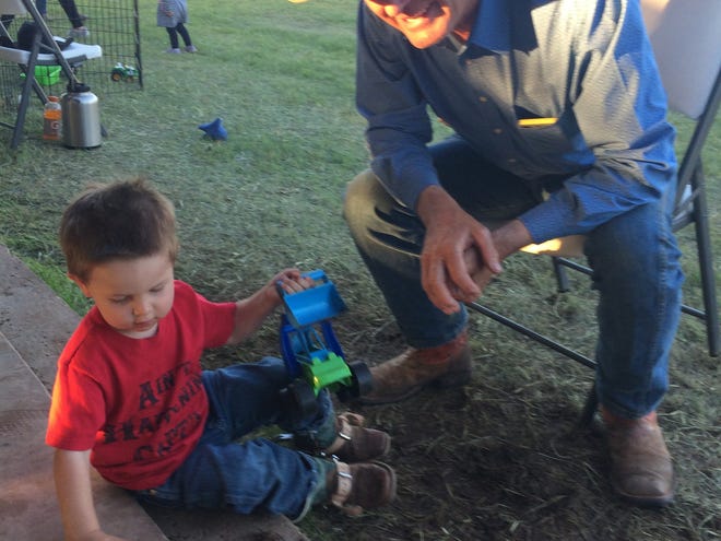 Jerry Bob Daniel plays with his grandson Auggie after dinner. Daniel hosted the 2019 annual veteran helicopter hog hunt on his Truscott, Texas, ranch.