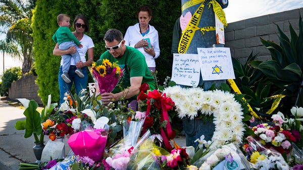 San Diego resident James Carmey places flowers at...