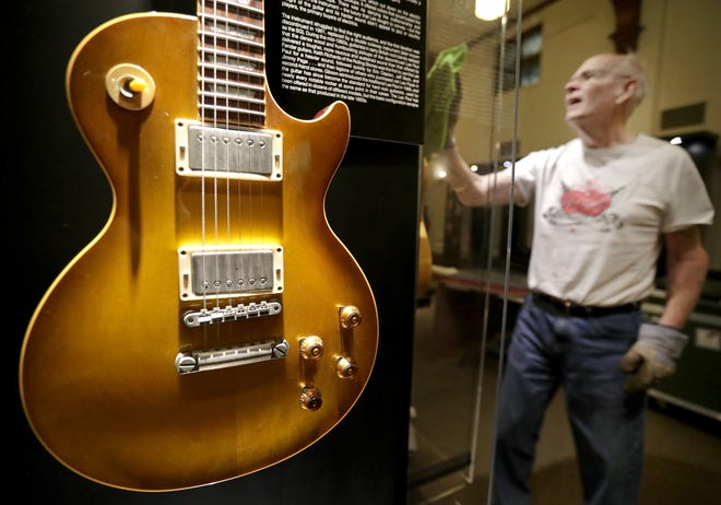 Volunteer Dick Rank cleans a display during installation of "Guitar: The Instrument That Rocked the World" at the History Museum at the Castle. The exhibition will be on display at the Appleton museum through Jan. 5.