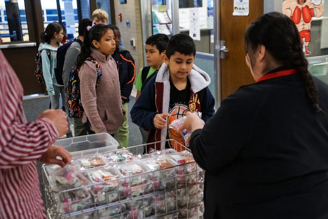 Cafeteria manager Dawn Medina, right passes out breakfast packets to students entering the Fairfield Elementary School in Fort Wayne on April 26, 2019, as part of the Community Eligibility Provision (CEP) program which reimburses eligible public and private school systems and schools for serving meals free of charge to all students.