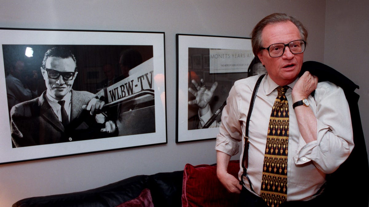 DATE TAKEN: 4/22/97--- Larry King looks at a photo of himself which hangs in his office. It shows King at the age of 27 during his first job in television, at WLBW in Miami. ORG XMIT: UT44455