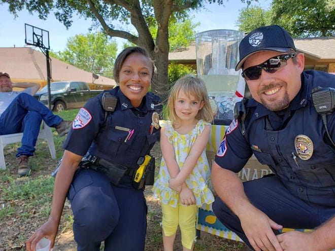 Harley Ratliff poses with two San Angelo Police officers at her lemonade stand Sunday, April 28, 2019.