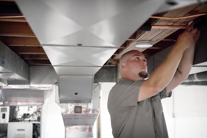 Spencer Hollifield, an HVAC mechanic with Gentry Heating, Inc., works to change out an old furnace for a heat pump at a house in Canton on April 30, 2019. Hollifield has been with the company for three years after going to school for the trade for a year. 