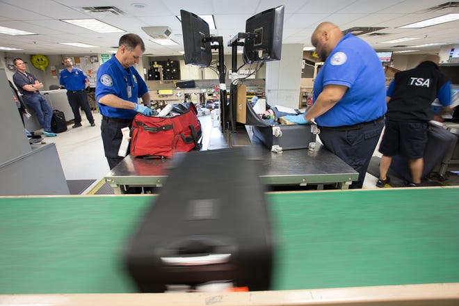 TSA agents inspect checked bags that have been flagged by security systems at Dallas-Fort Worth International Airport in April 2019.
