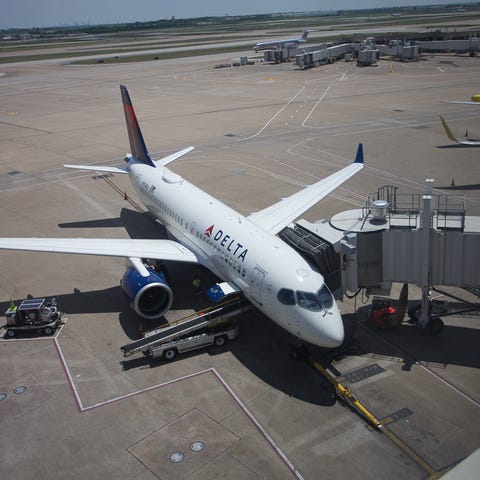 A Delta Air Lines Airbus A220 rests between...